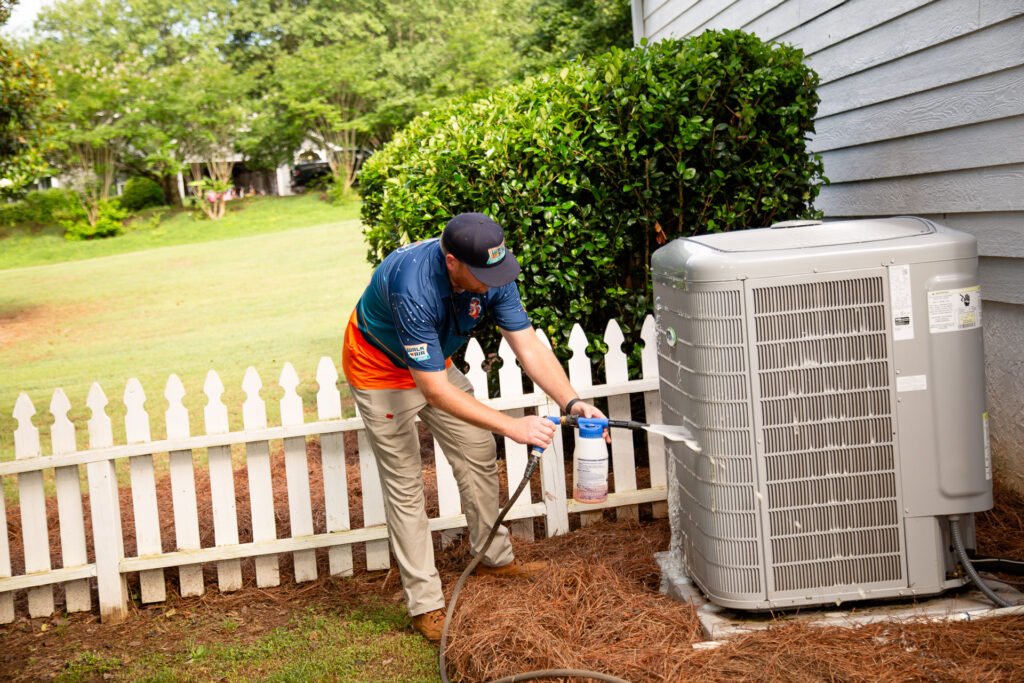 HVAC Technician cleaning outdoor hvac unit
